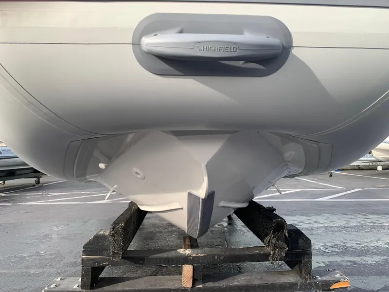 Slide: The Image of 2026 Highfield Sport 330 inflatable boat with Tohatsu engine, displayed indoors. - 9