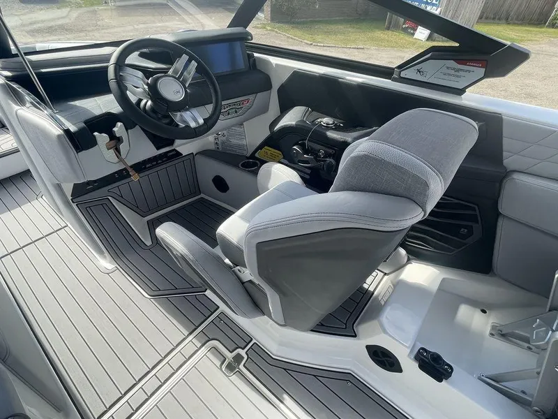 Slide: The Image of 2022 Nautique Super Air Nautique G23 boat interior, featuring steering wheel and captain's chair. - 9