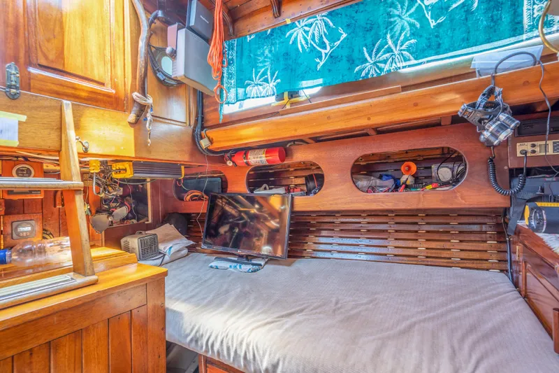 Slide: The Image of 1950 Custom Cornu Sloop interior with wooden cabinetry, bed, and nautical decor. - 10