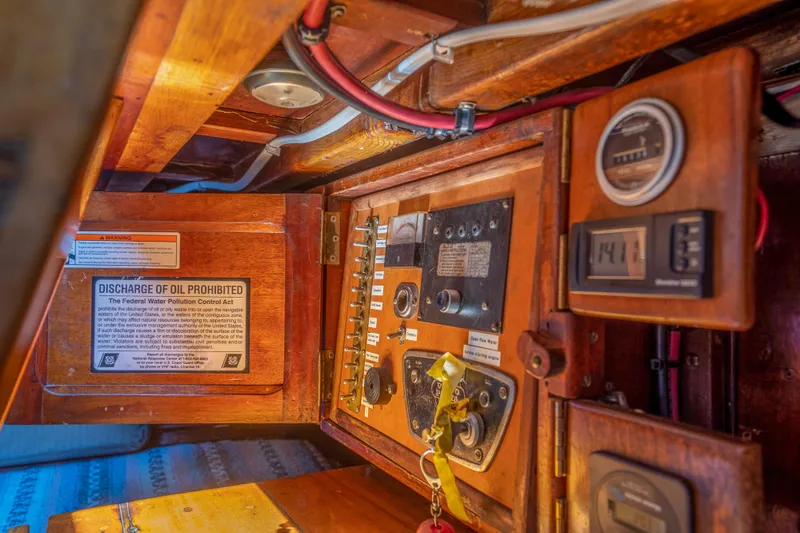 Slide: The Image of 1950 Custom Cornu Sloop electrical panel with vintage gauges and oil discharge prohibition sign. - 11