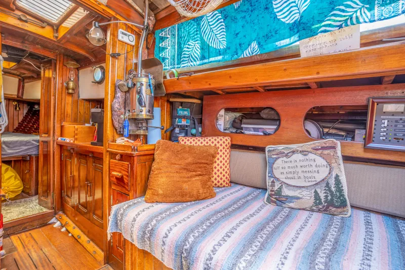 Slide: The Image of 1950 Custom Cornu Sloop interior with cozy seating, wooden finishes, and nautical decor. - 13