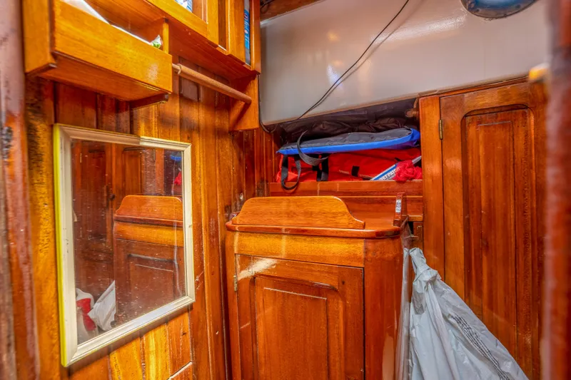 Slide: The Image of 1950 Custom Cornu Sloop interior with wooden cabinetry and mirror. - 16