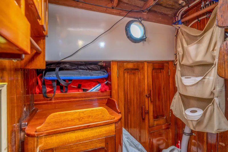 Slide: The Image of 1950 Custom Cornu Sloop interior with wooden cabinetry and porthole. - 17