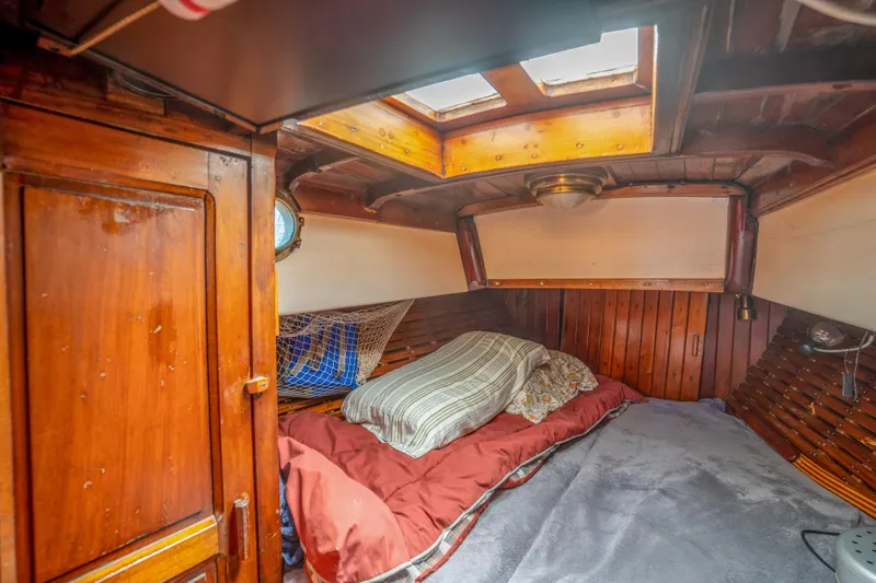 Slide: The Image of 1950 Custom Cornu Sloop cabin interior with wooden paneling and cozy bedding. - 18