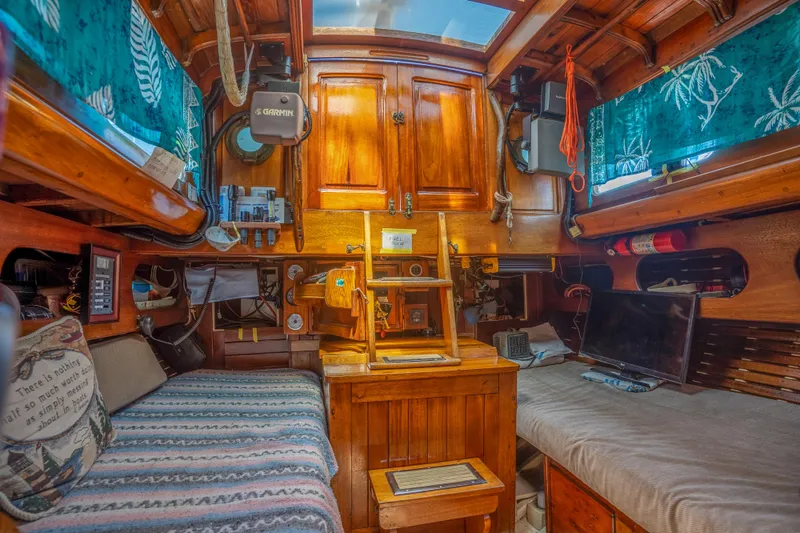 Slide: The Image of Interior of a 1950 Custom Cornu Sloop with wooden cabinetry and cozy seating. - 20