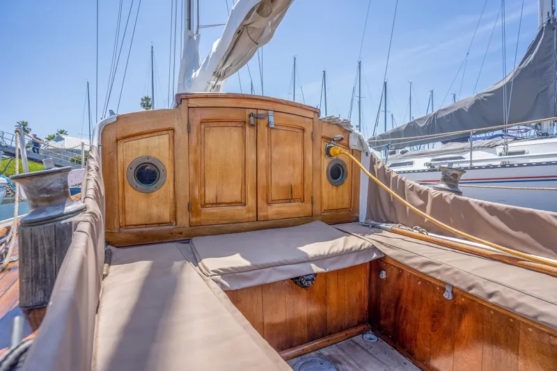 Slide: The Image of 1950 Custom Cornu Sloop sailboat cockpit with wooden cabinetry and cushioned seating. - 24