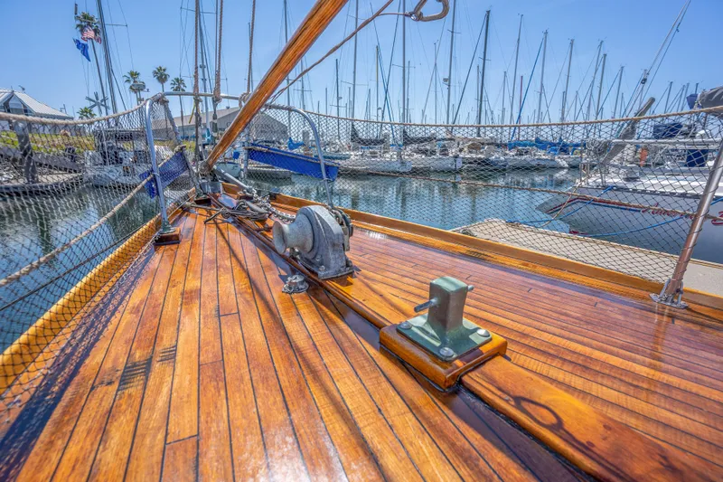 Slide: The Image of 1950 Custom Cornu Sloop sailboat deck with polished wood finish in marina. - 26
