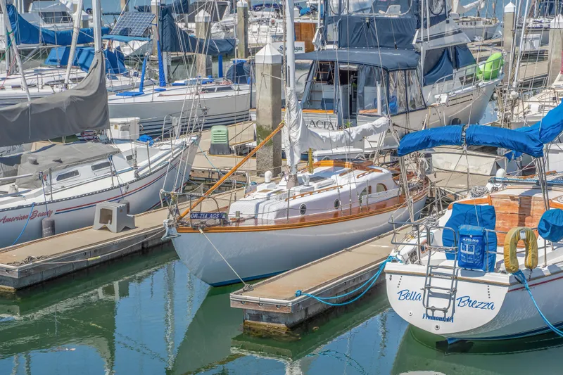 Slide: The Image of 1950 Custom Cornu Sloop docked among other sailboats in a marina. - 27