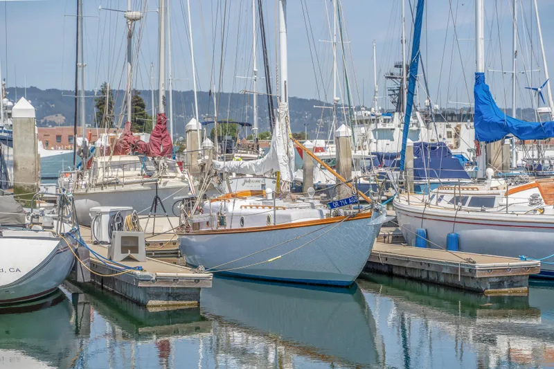 Slide: The Image of 1950 Custom Cornu Sloop docked in a marina with other sailboats. - 28