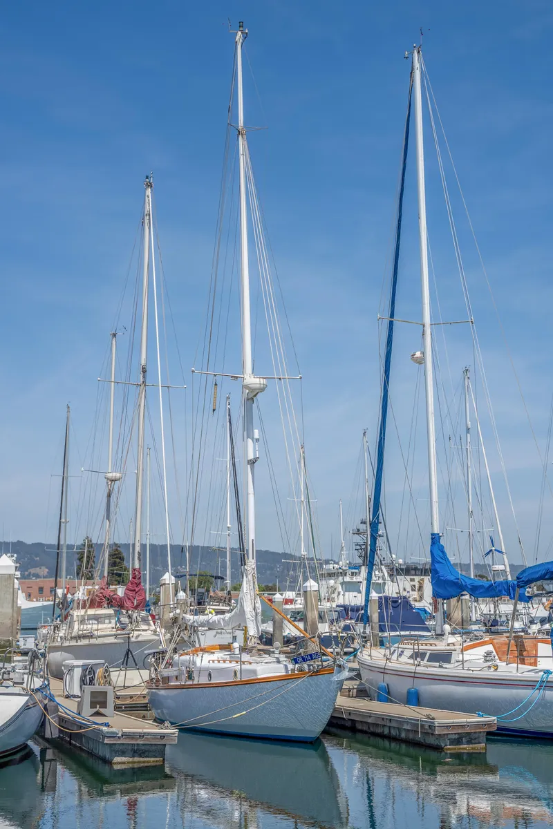 Slide: The Image of 1950 Custom Cornu Sloop docked at a marina with other sailboats. - 29