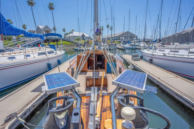Slide: The Image of 1950 Custom Cornu Sloop sailboat docked in a marina with solar panels. - 3