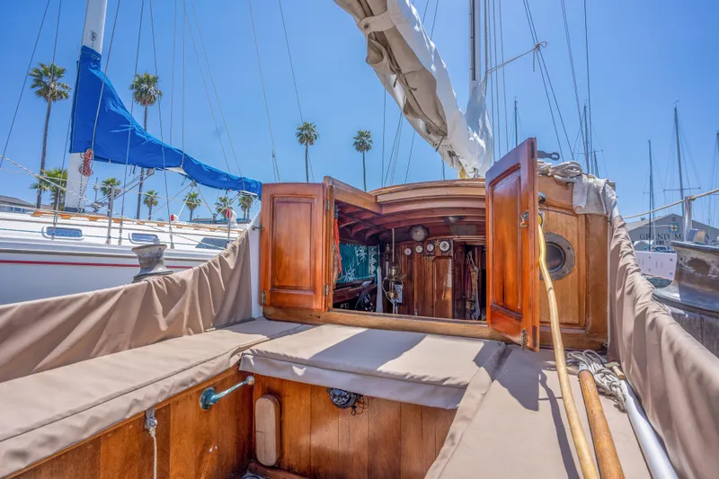 Slide: The Image of 1950 Custom Cornu Sloop sailboat with open cabin, docked in marina. - 6
