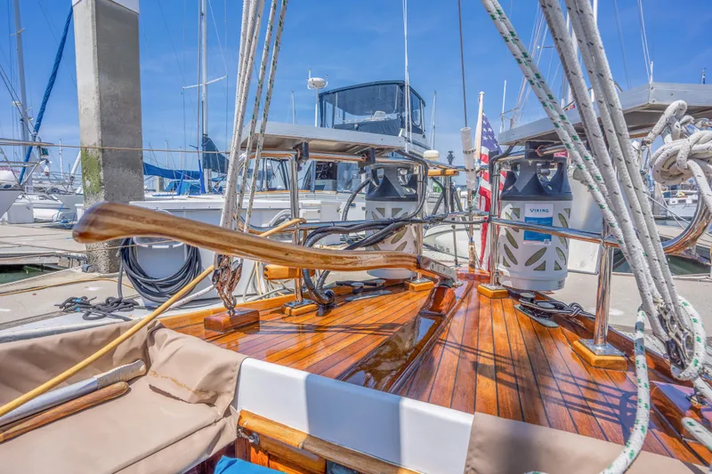 Slide: The Image of 1950 Custom Cornu Sloop with polished wooden deck at marina. - 7