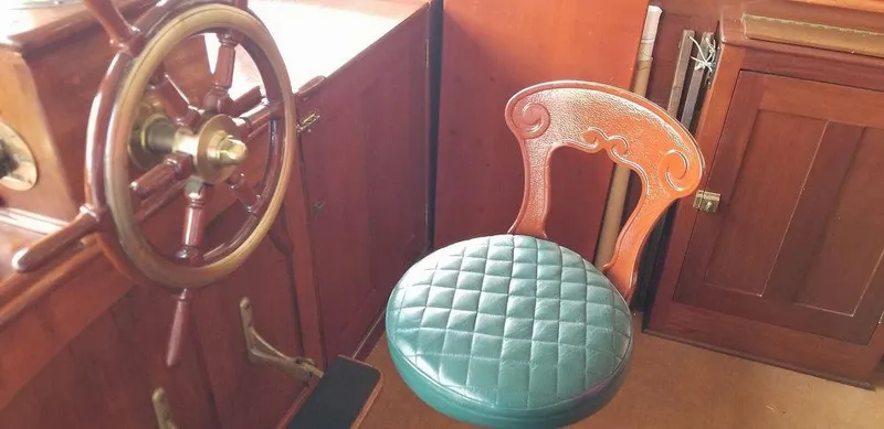 Slide: The Image of 1928 Elco Flat Top boat interior with wooden steering wheel and cushioned chair. - 28