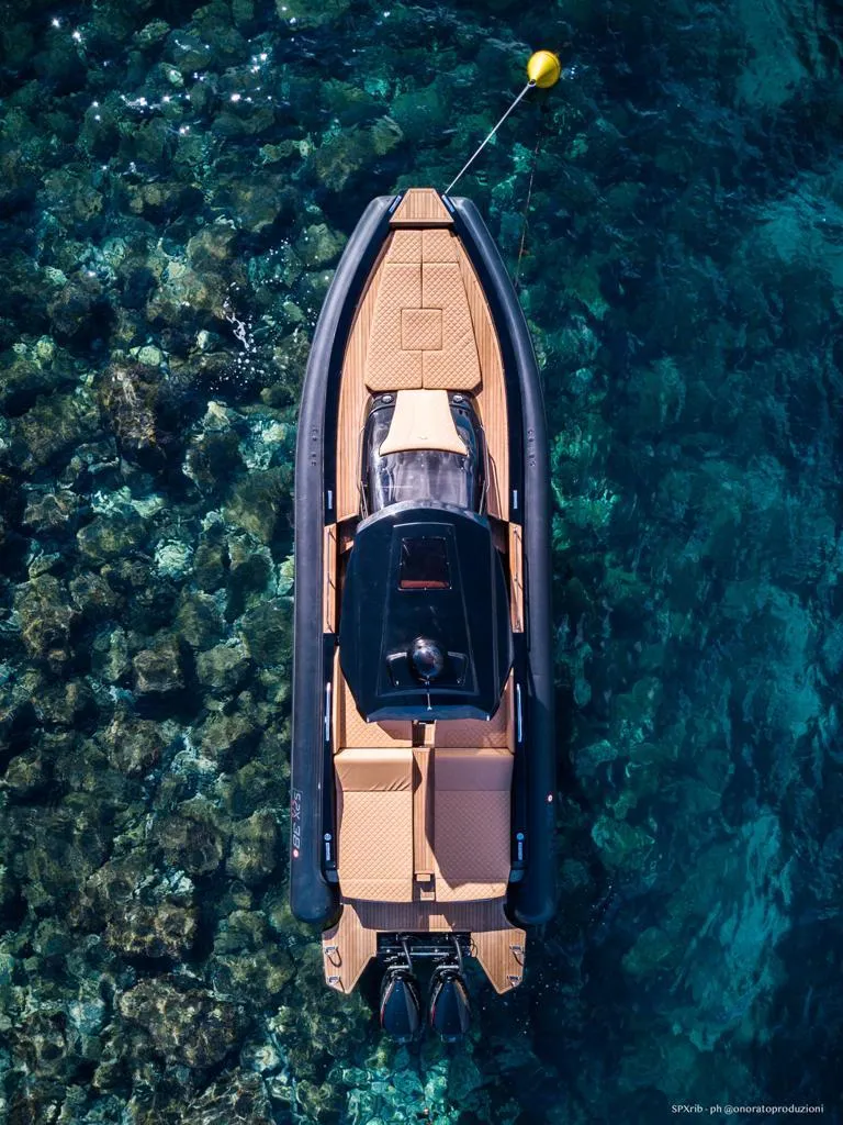 Slide: The Image of 2025 SPX RIB 38 Sport boat cruising over clear blue water. - 11