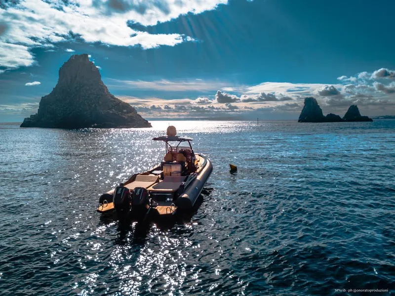 Slide: The Image of SPX RIB 38 Sport 2025 boat on serene ocean with rocky islands in the background. - 12