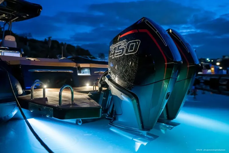 Slide: The Image of 2025 SPX RIB 38 Sport boat with twin outboard engines at dusk. - 17