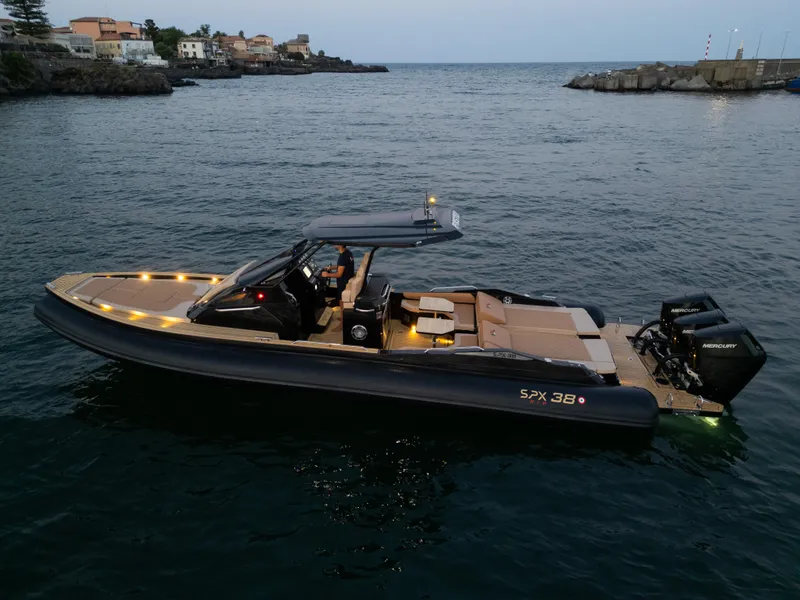 Slide: The Image of 2025 SPX RIB 38 Sport boat on calm water at dusk. - 3