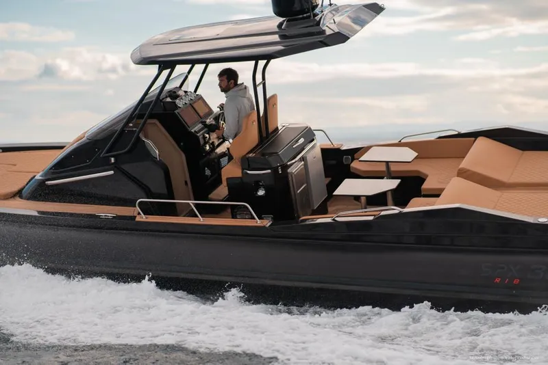 Slide: The Image of 2025 SPX RIB 38 Sport boat cruising on water with a man at the helm. - 4
