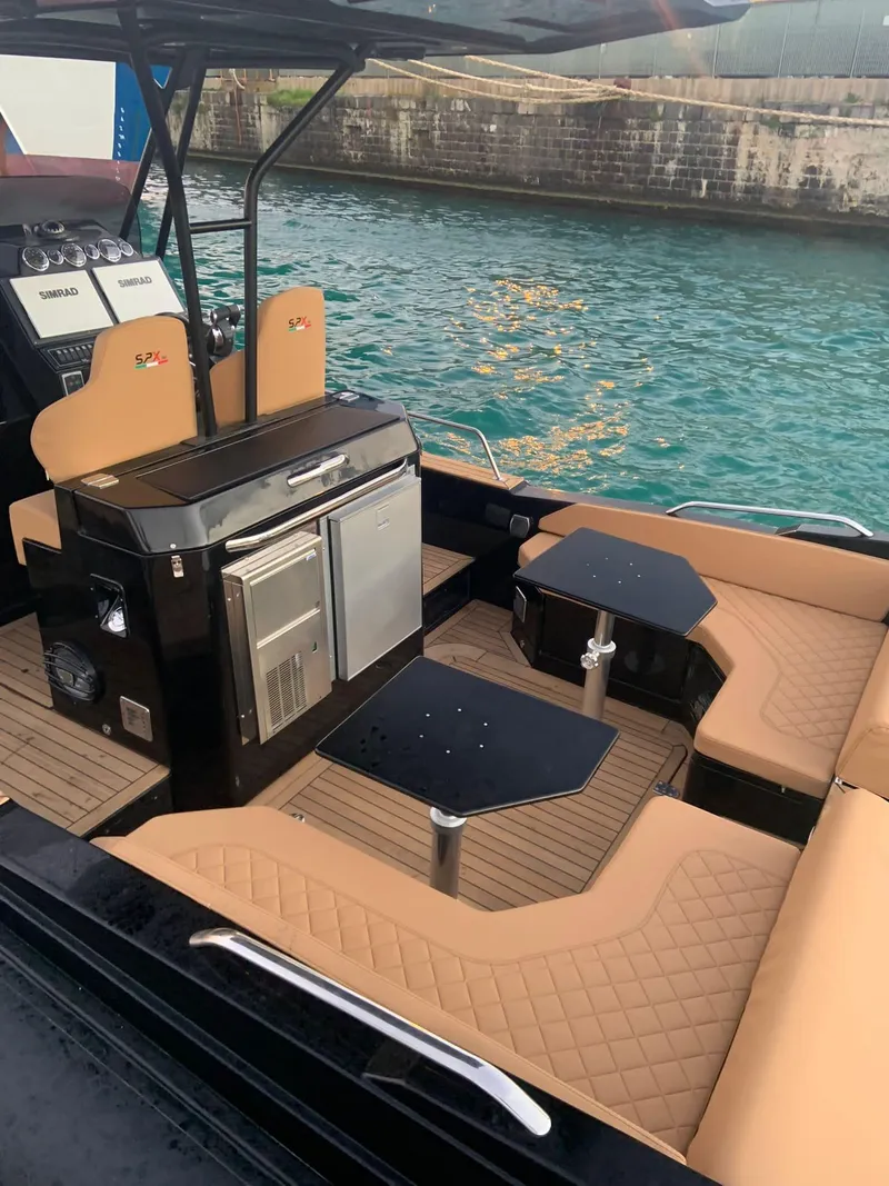 Slide: The Image of 2025 SPX RIB 38 Sport boat interior with tan seating and black fixtures. - 9
