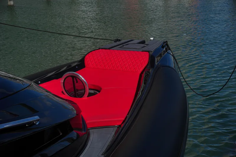 Slide: The Image of 2025 Sea Prop COMFORT 33 boat with red seating and black exterior on water. - 10