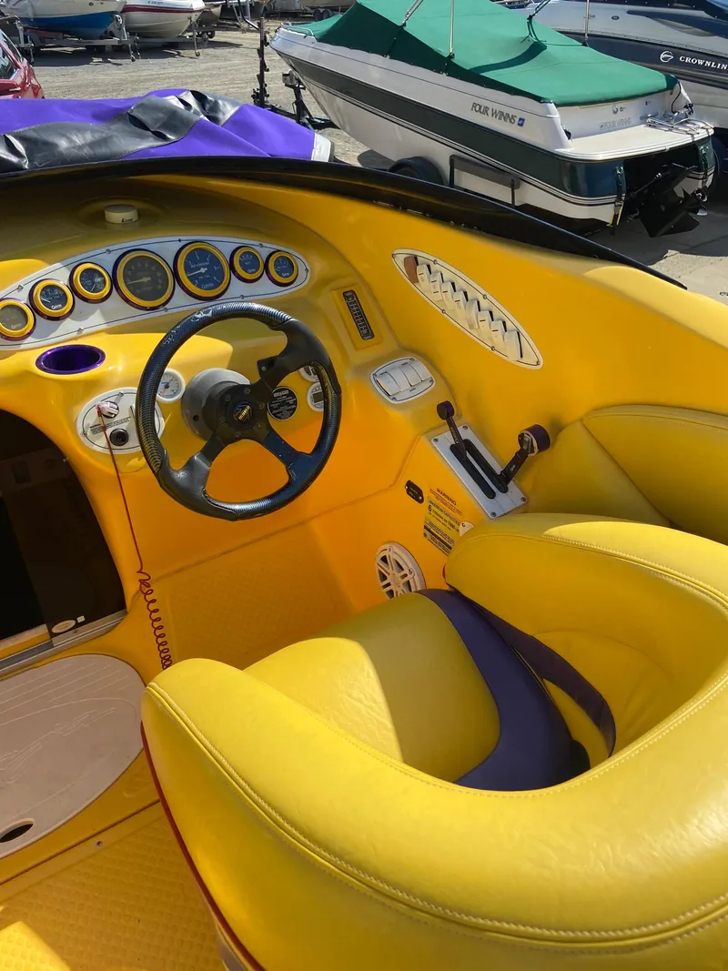 Slide: The Image of 2001 Baja H2X boat interior with yellow and purple seats and dashboard. - 19
