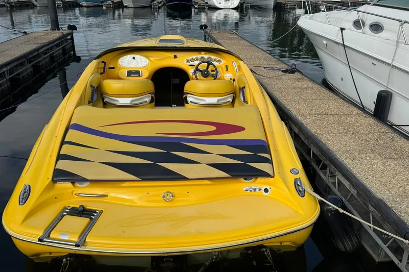 Slide: The Image of Yellow 2001 Baja H2X speedboat docked at marina, featuring vibrant design and sleek interior. - 2