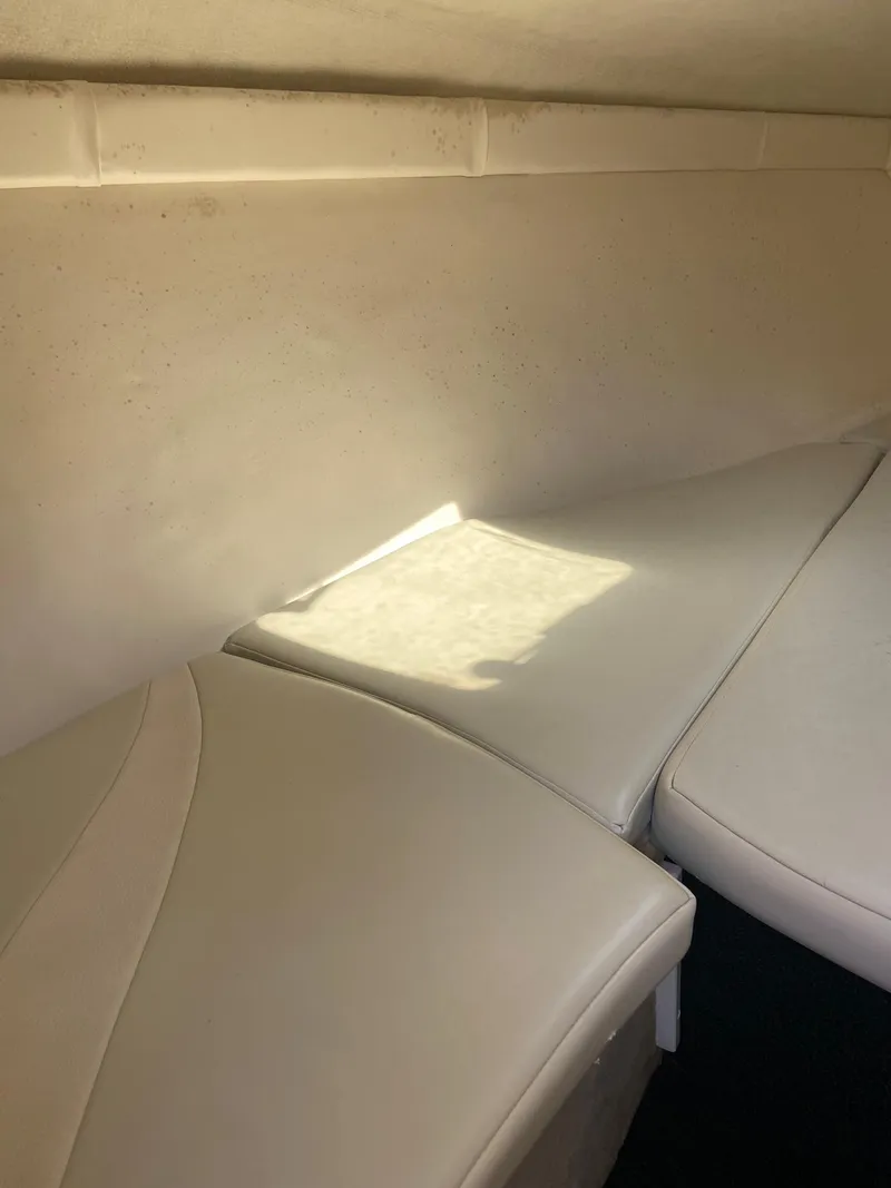 Slide: The Image of Interior cabin of a 2001 Baja H2X boat with white cushioned seating. - 23