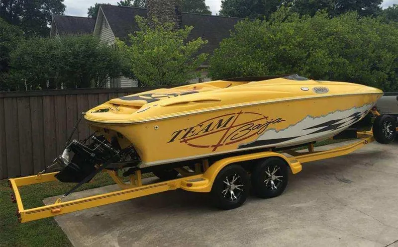 Slide: The Image of 2001 Baja H2X speedboat on a yellow trailer in a driveway. - 3