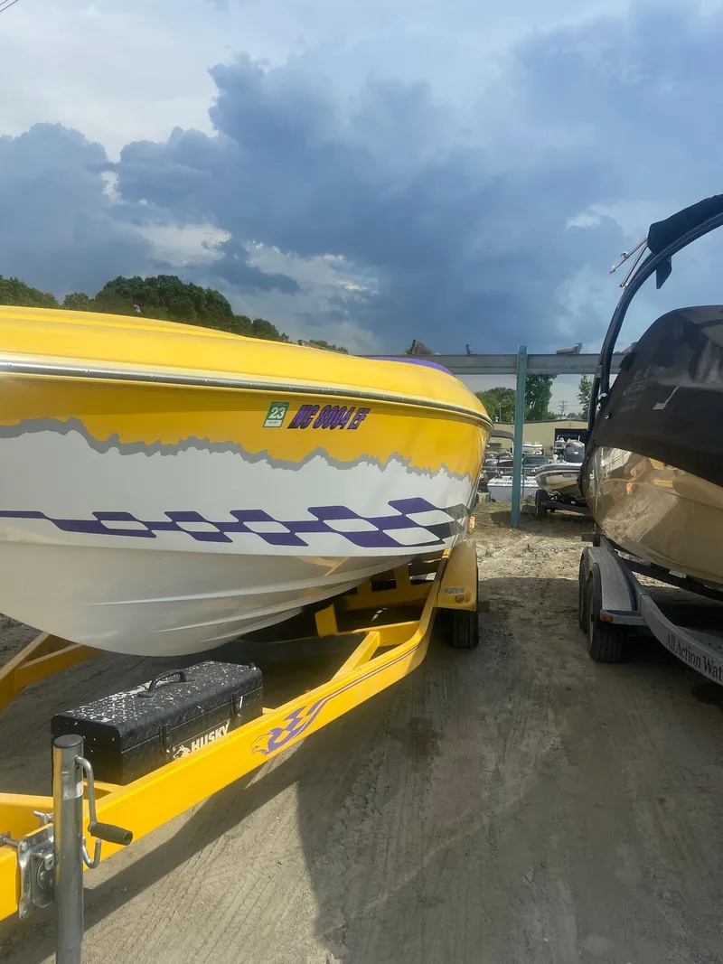 Slide: The Image of 2001 Baja H2X speedboat with yellow and white design on a trailer. - 8