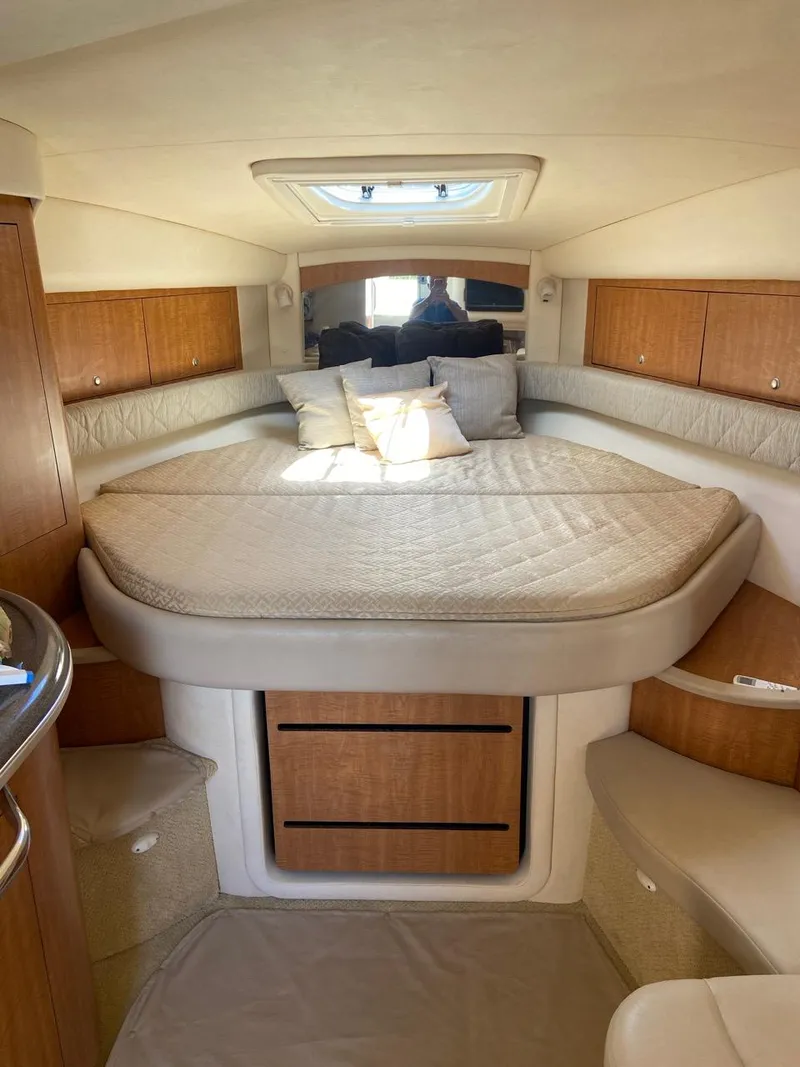 Slide: The Image of 2006 Sea Ray 340 Sundancer cabin with bed, wooden cabinets, and skylight. - 17