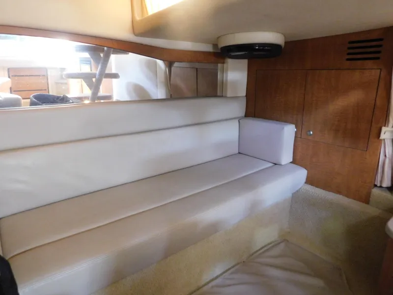 Slide: The Image of Interior seating area of 2006 Sea Ray 340 Sundancer yacht with white cushions and wooden cabinetry. - 22