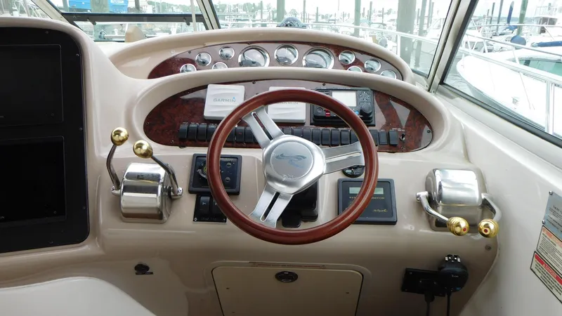 Slide: The Image of Helm of 2002 Sea Ray 380 Sundancer with wood-accented steering wheel and control panel. - 14