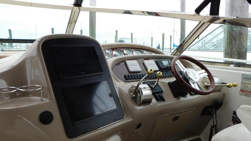 Slide: The Image of 2002 Sea Ray 380 Sundancer helm with steering wheel and control panel. - 31
