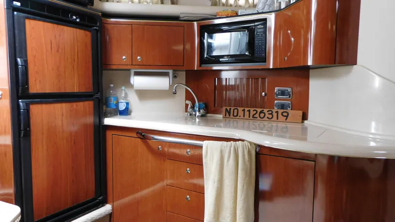 Slide: The Image of Interior of 2002 Sea Ray 380 Sundancer yacht kitchen with wood cabinetry and appliances. - 34