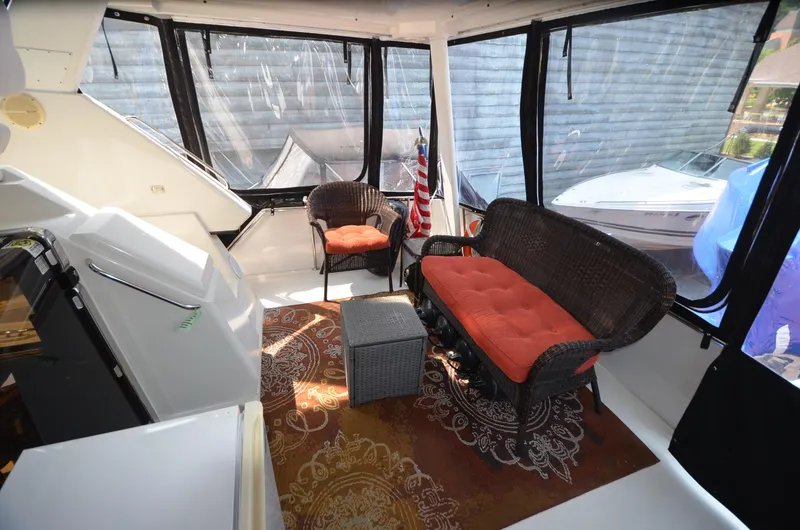 Slide: The Image of 1991 Carver 33 Aft Cabin interior with wicker seating and decorative rug. - 8