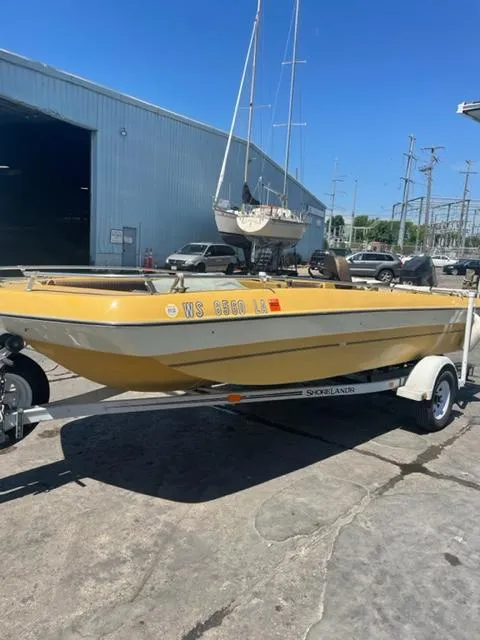 Slide: The Image of 1977 Yarcraft Spirit of 76 boat on trailer, parked near industrial building. - 1