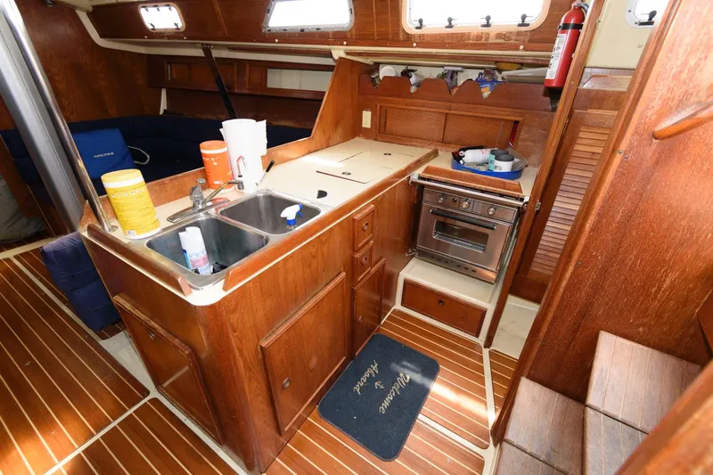 Slide: The Image of 1987 Pearson 36-2 sailboat interior galley with wooden cabinetry, sink, stove, and storage. - 11