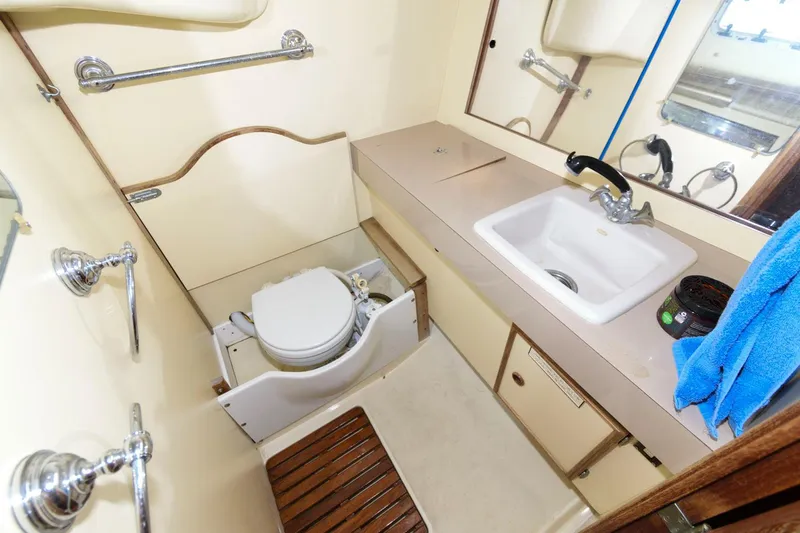 Slide: The Image of 1987 Pearson 36-2 sailboat bathroom with sink, toilet, and wooden seat. - 12