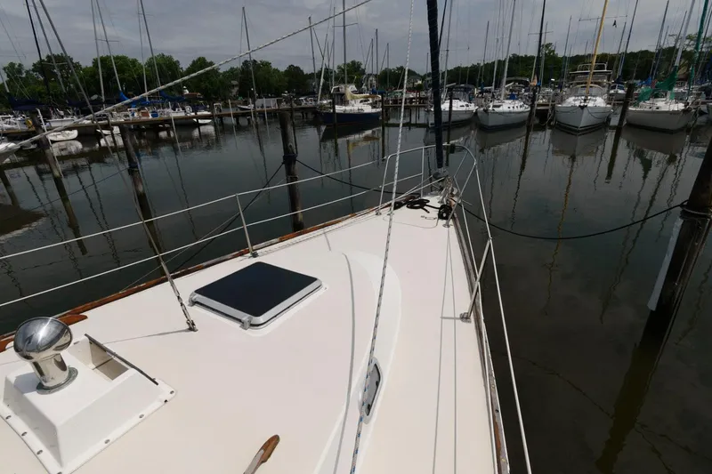 Slide: The Image of 1987 Pearson 36-2 sailboat docked at a marina, view of the deck and surrounding boats. - 3