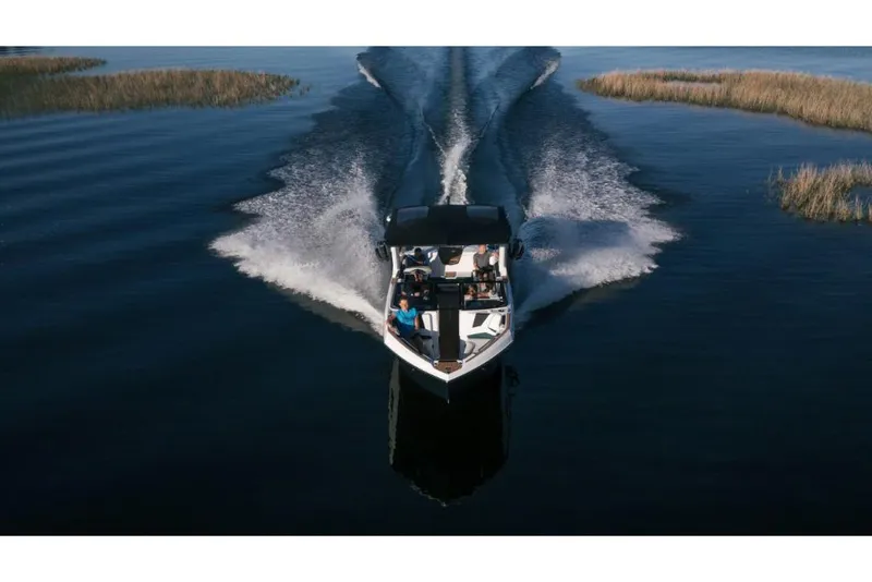 Slide: The Image of 2023 Nautique Super Air Nautique S25 boat cruising on a lake. - 20