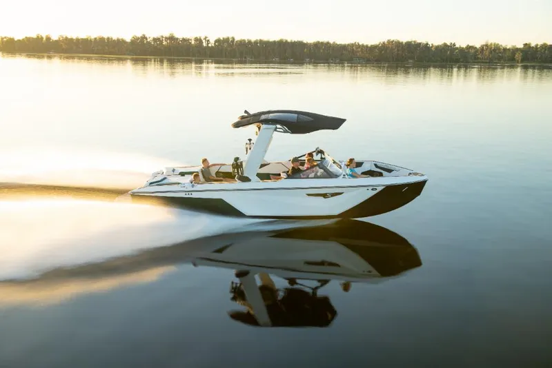 Slide: The Image of 2023 Nautique Super Air Nautique S25 cruising on a calm lake at sunset. - 21
