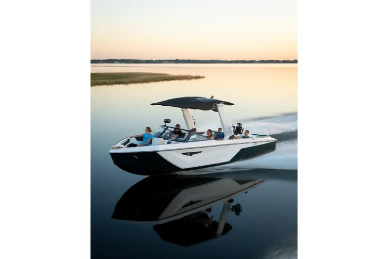 Slide: The Image of 2023 Nautique Super Air Nautique S25 cruising on a calm lake at sunset. - 27