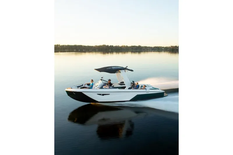 Slide: The Image of 2023 Nautique Super Air Nautique S25 cruising on a calm lake at sunset. - 29