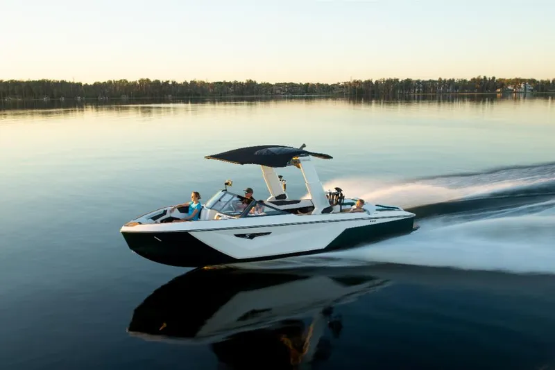 Slide: The Image of 2023 Nautique Super Air Nautique S25 speeding on a calm lake at sunset. - 33