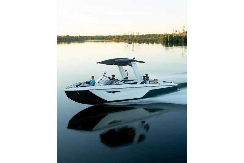 Slide: The Image of 2023 Nautique Super Air Nautique S25 cruising on a calm lake at sunset. - 36