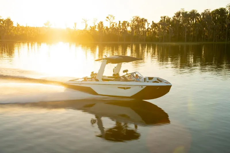 Slide: The Image of 2023 Nautique Super Air Nautique S25 boat cruising on a lake at sunset. - 39