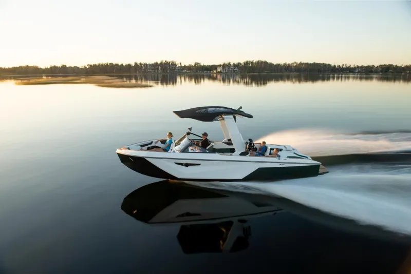 Slide: The Image of 2023 Nautique Super Air Nautique S25 cruising on a calm lake at sunset. - 4