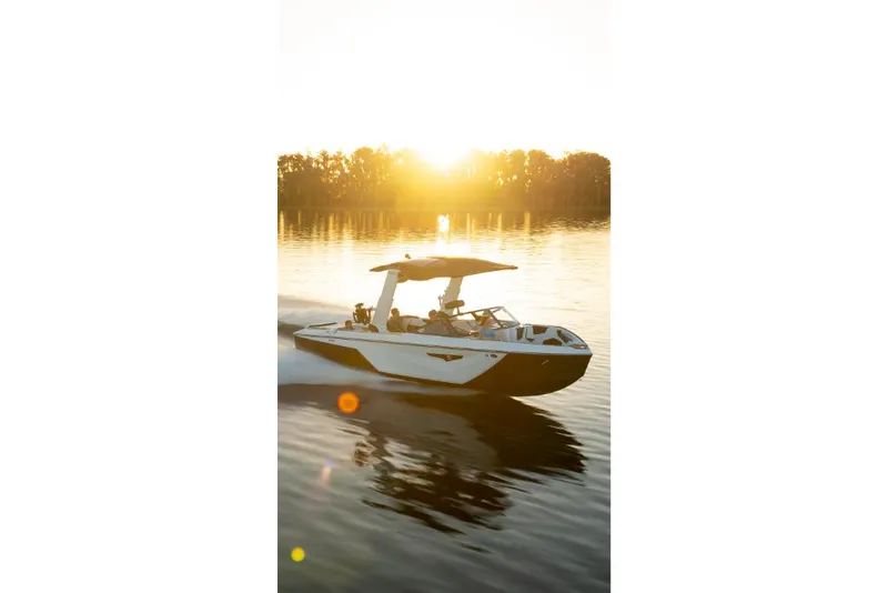 Slide: The Image of 2023 Nautique Super Air Nautique S25 boat cruising at sunset on a calm lake. - 40