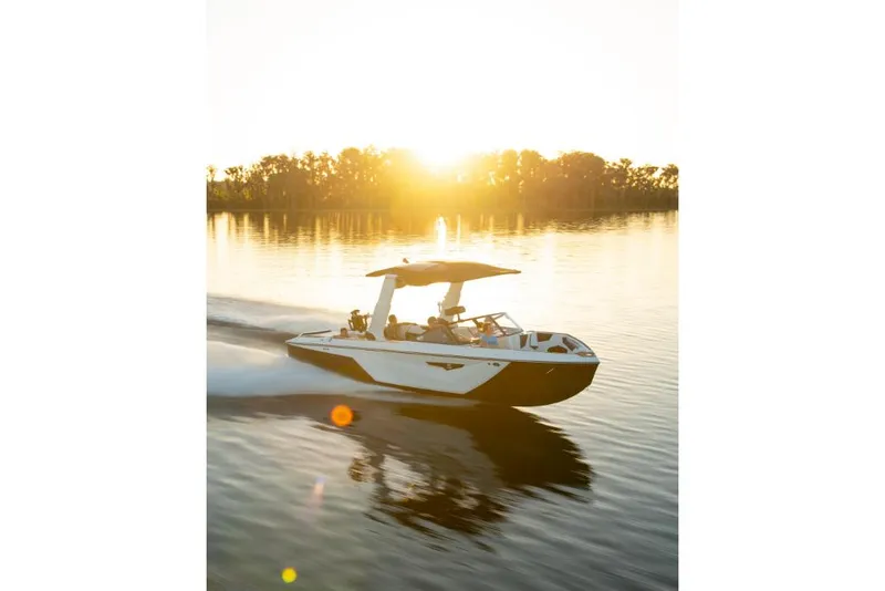 Slide: The Image of 2023 Nautique Super Air Nautique S25 boat cruising on a lake at sunset. - 41
